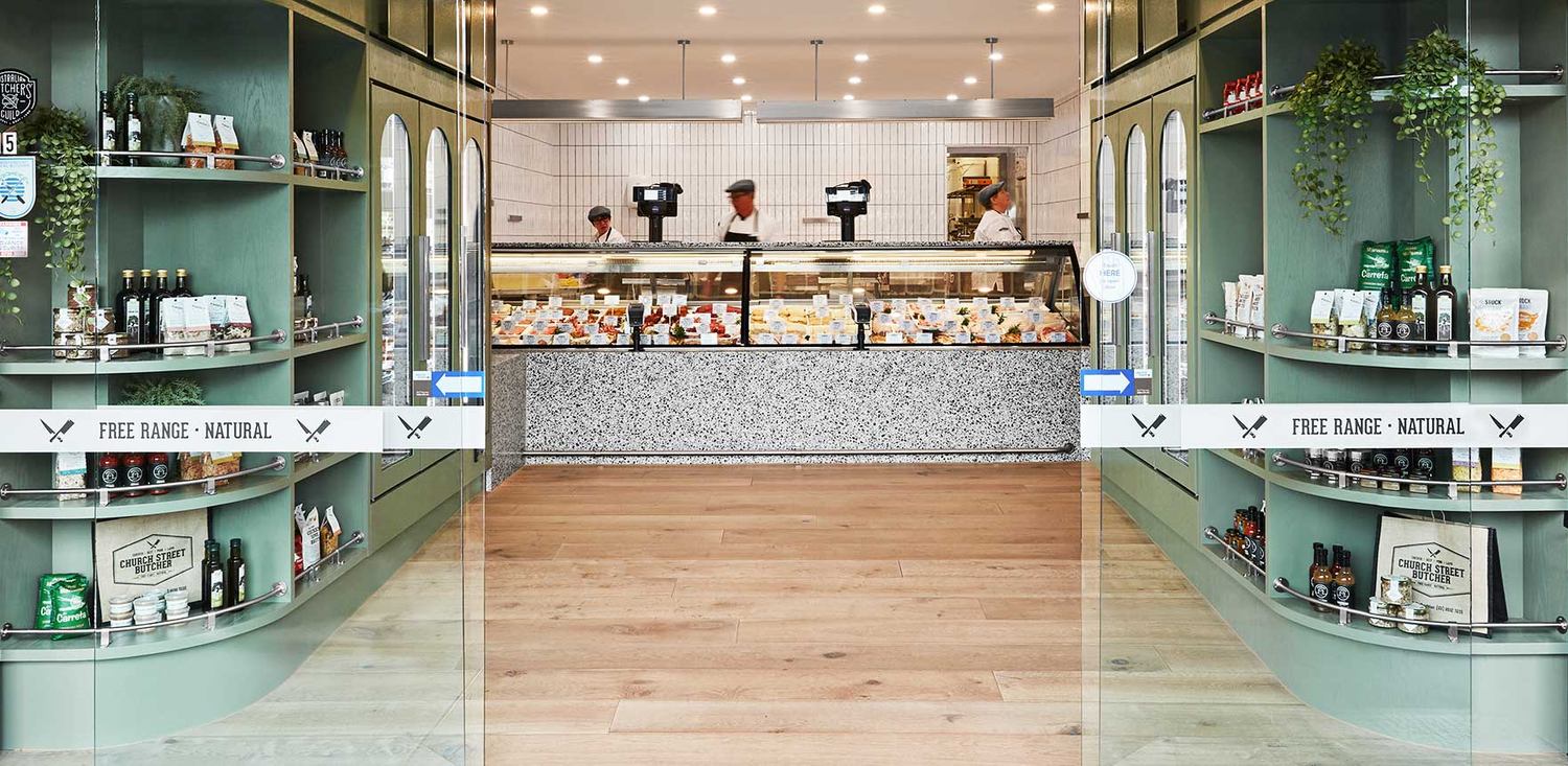 Looking in from Church Street: the shelves either side, the counter ahead and the butchers behind it.